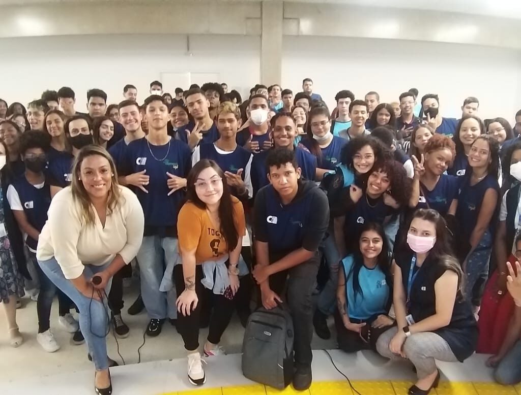 Um grupo de pessoa em meio circulo virados para a camera