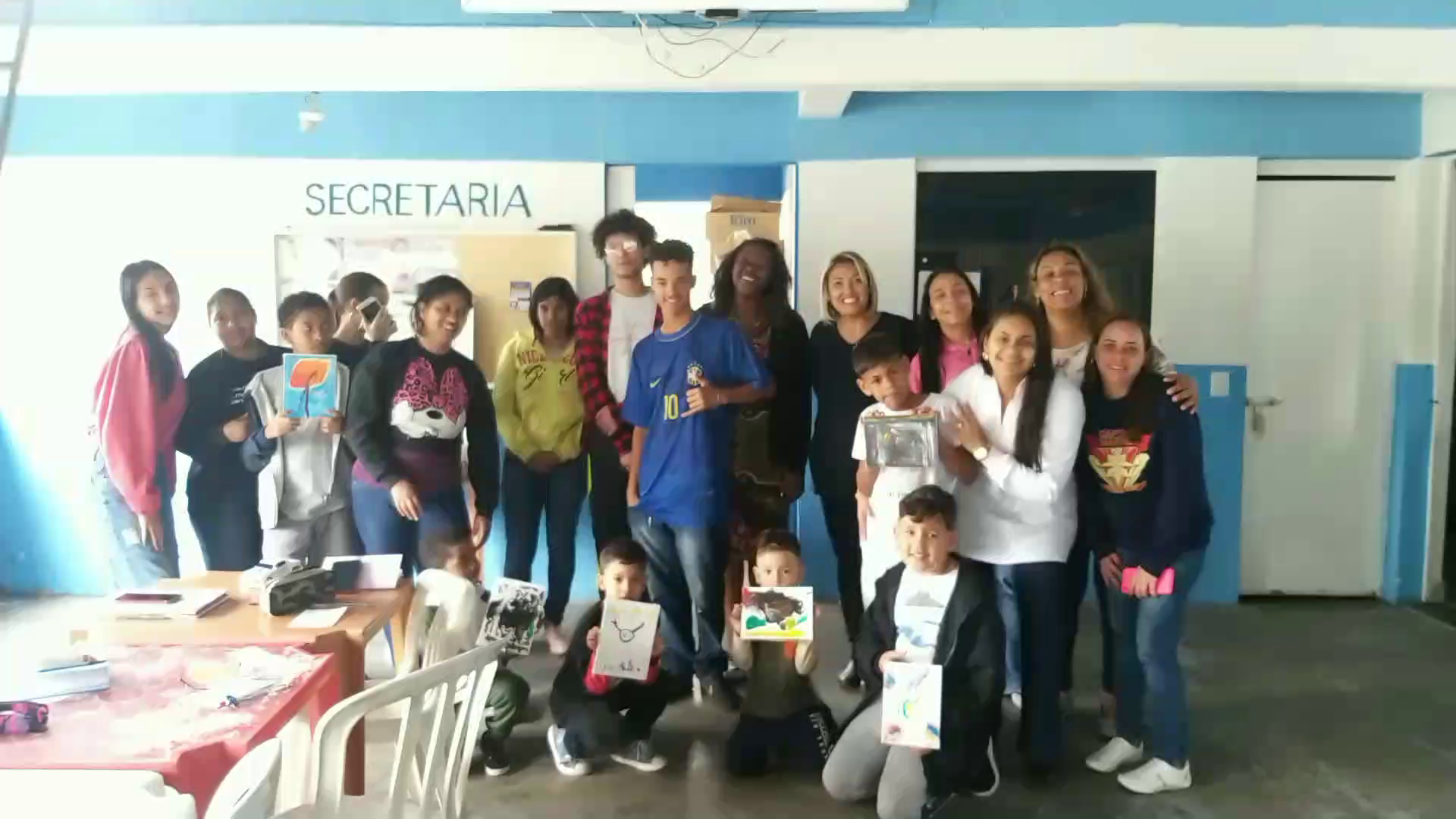 Um grupo de pessoas contra a parede olhando para a camera